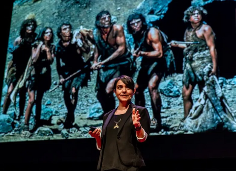 Paloma standing before and image of six neanderthals
